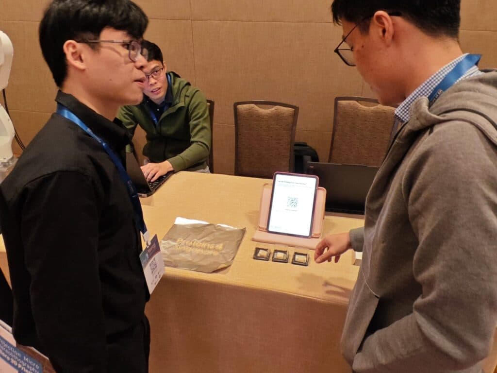 Researchers demonstrating 3D-printed food samples to a visitor